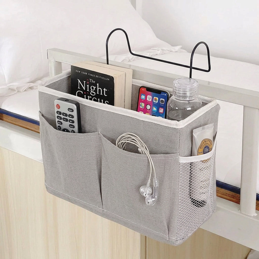 Gray caddy with compartments holding various items, attached to a white surface.

